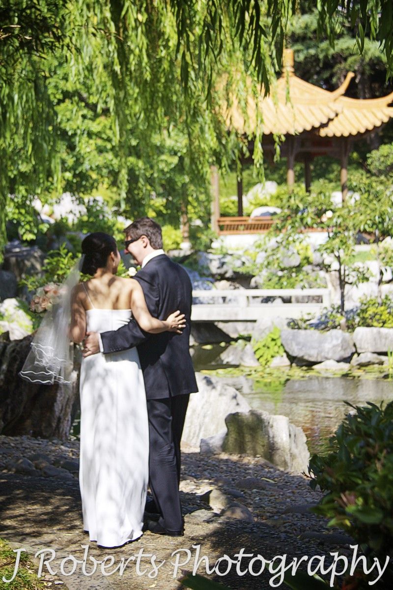 Bride and groom wandering arm in arm around the chinese gardens - wedding photography sydney